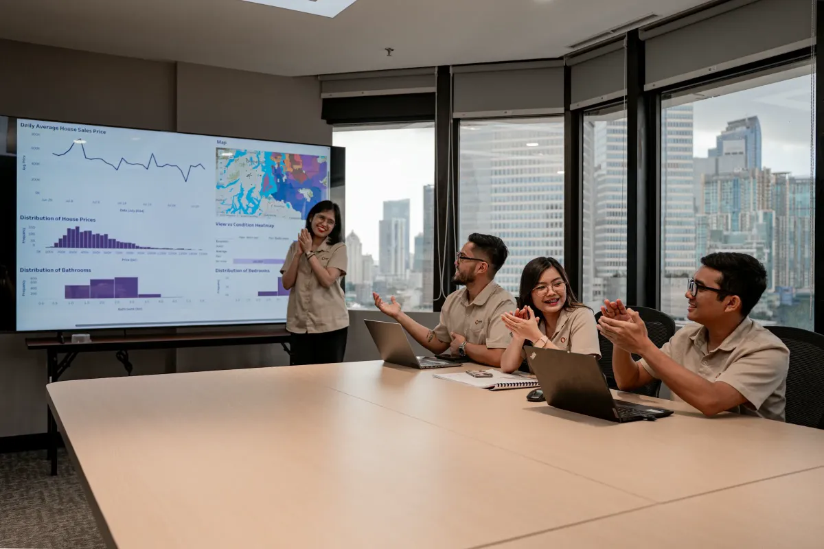 A team reviewing data on a large screen in a meeting room
